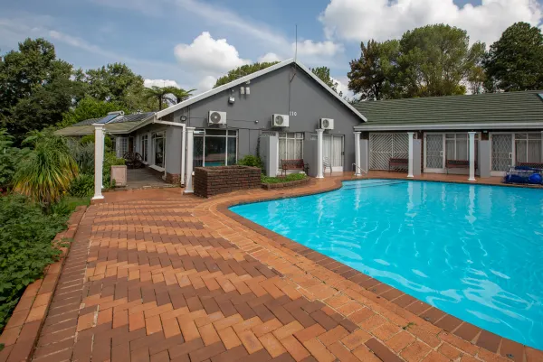 Swimming pool with main building and lush plants