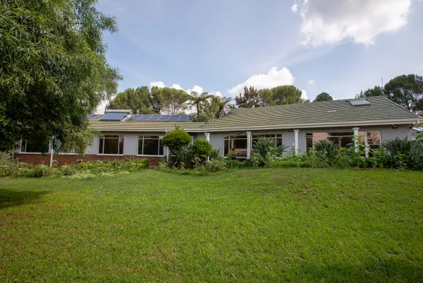 Rear garden with green lawn and garden beds