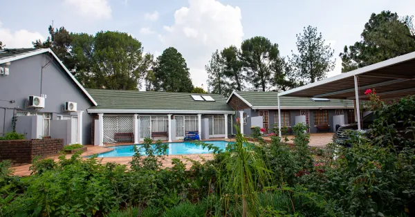 Panoramic view of pool, buildings, and rose garden