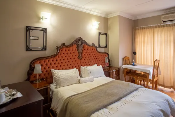 Room 1 — Queen bed with ornate tufted headboard